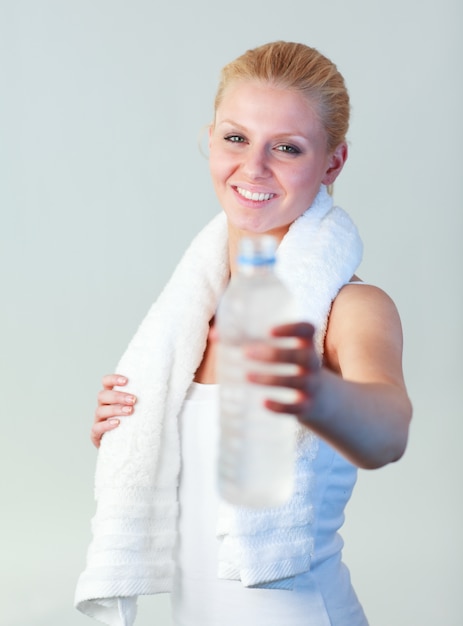 Portret van een aantrekkelijke vrouw die een fles water en een handdoeknadruk op vrouw houdt