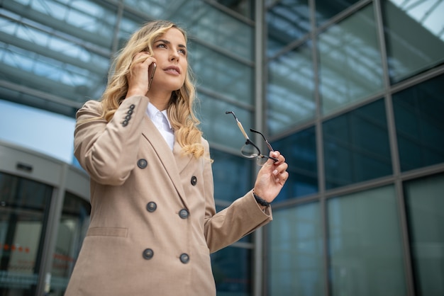 Portret van een aantrekkelijke vrouw die op de telefoon spreekt