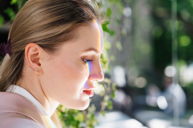 Portret van een aantrekkelijke vrouw met regenbooglicht over het gezicht