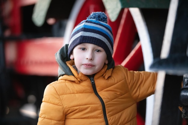 Portret van een achtjarige jongen in een jas en hoed