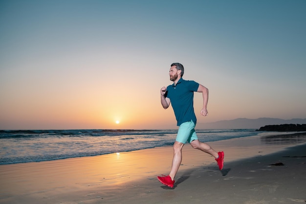 Portret van een actieve man van middelbare leeftijd die buiten over zee jogt