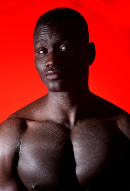 Portret van een Afrikaanse man shirtless op rode achtergrond