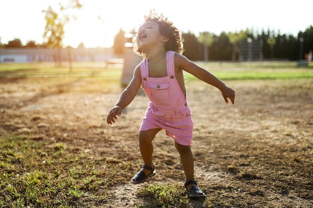 Foto portret van een afro-amerikaanse baby die plezier heeft in het park.