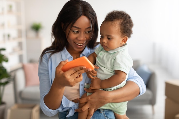 Portret van een Afro-Amerikaanse familie die thuis mobiele telefoon gebruikt