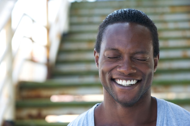 Portret van een Afro-Amerikaanse man lachen met gesloten ogen