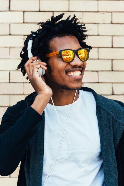 Portret van een afro-knappe man die muziek op straat luistert.