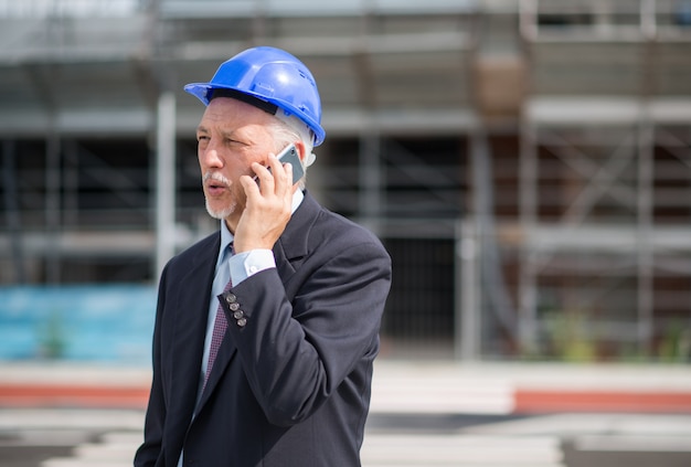 Portret van een architect die aan de telefoon aan zijn aannemer spreekt