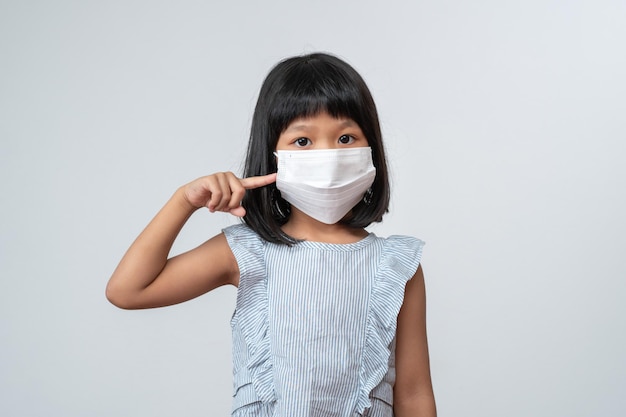 Portret van een Aziatisch meisje met een beschermend gezichtsmasker klaar voor school met pandemische beperkingen