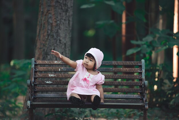 Portret van een Aziatisch meisje zit op een bankje bij de mensen van parkThailand