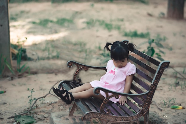 Portret van een Aziatisch meisje zit op een bankje bij de mensen van parkThailand