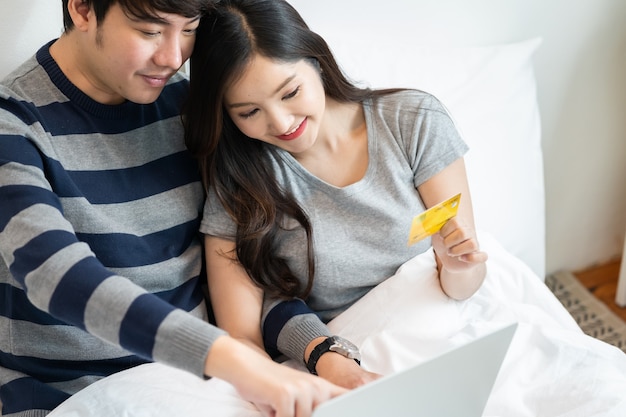 portret van een Aziatisch vrolijk stel dat online winkelt op internet met een laptopcomputer