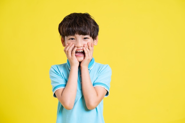 Portret van een Aziatische jongen die zich voordeed op een gele achtergrond