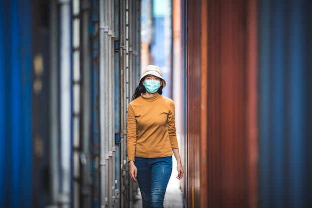 Portret van een Aziatische vrouw die een chirurgisch masker draagt om de infectie door het coronavirus COVID-19-virus te voorkomen.