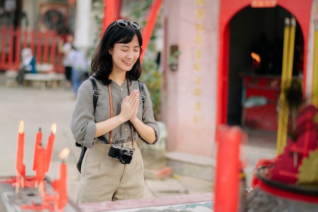 Portret van een aziatische vrouw die gebeden uitspreekt en de ogen sluiten voor het lokale Chinese heiligdom in Bangkok, Thailand