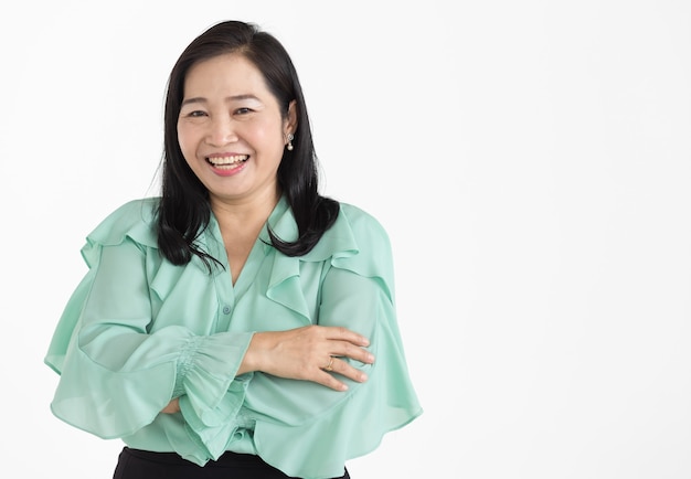 Portret van een Aziatische vrouw van middelbare leeftijd die een mintgroene blouse draagt en er netjes uitziet en prachtig glimlacht met zelfverzekerd geïsoleerd.