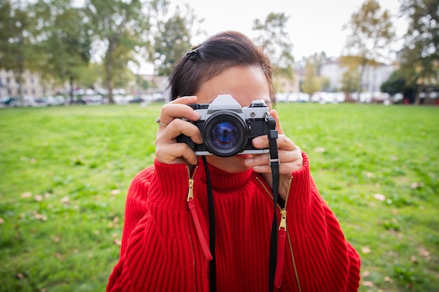 Portret van een Aziatische vrouwelijke fotograaf met analoge camera klaar om een foto te maken