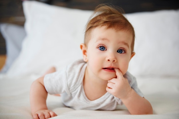 Portret van een baby dat thuis op bed ligt