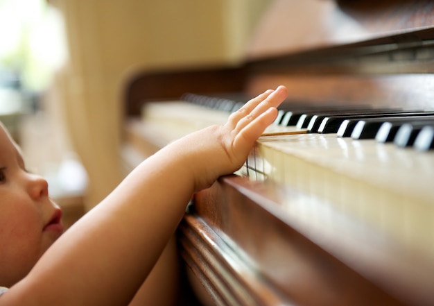 Foto portret van een baby die de piano speelt