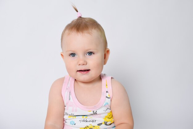 Foto portret van een baby op een witte achtergrond in een t-shirt het kind lacht en gelukkig