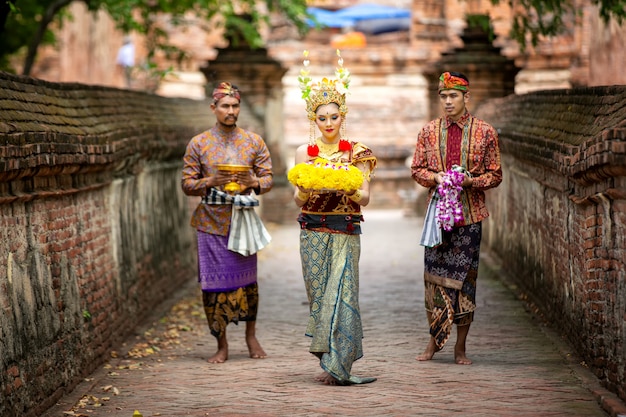 Portret van een balinese dansers houdt oblatie in traditionele kleding bij bali gate