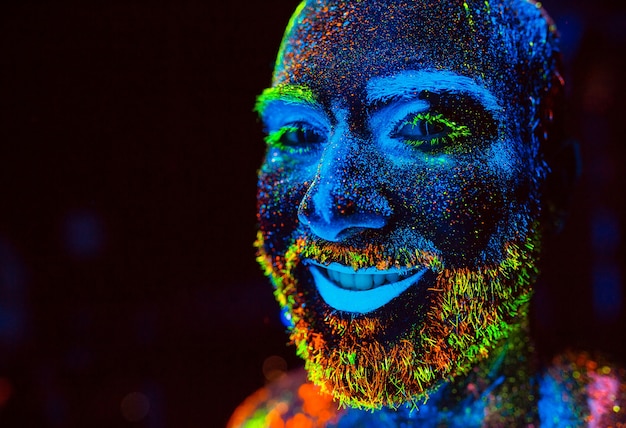 Portret van een bebaarde man geschilderd in fluorescerend poeder.