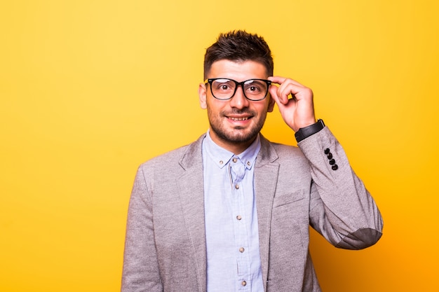 Portret van een bebaarde man in glazen met ernstige uitdrukking op gele achtergrond