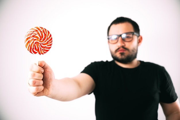 portret van een bebaarde man met bril met een grote ronde rode lolly