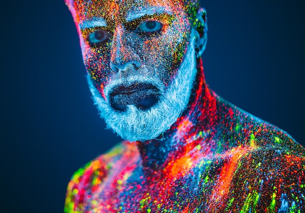 Foto portret van een bebaarde man met ultraviolet poeder