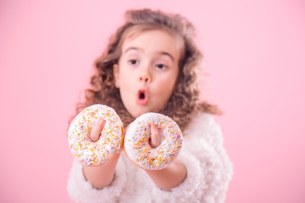 Portret van een beetje verrast meisje met donuts