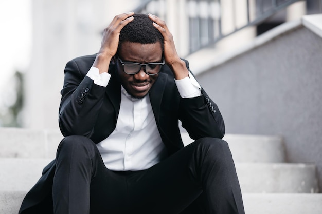 Portret van een bezorgde zakenman die zit na het verliezen van werkstress