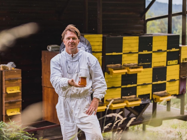 Portret van een bijenhouder bij een bijenkorf