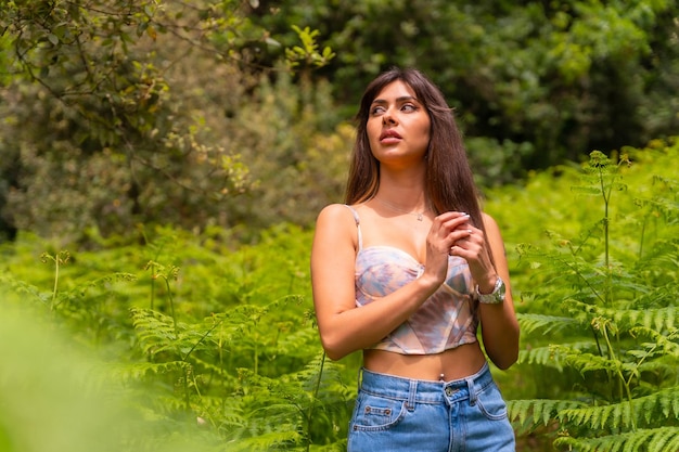 Portret van een blank meisje in varens op een berg midden in de natuur, genietend van de frisse lucht