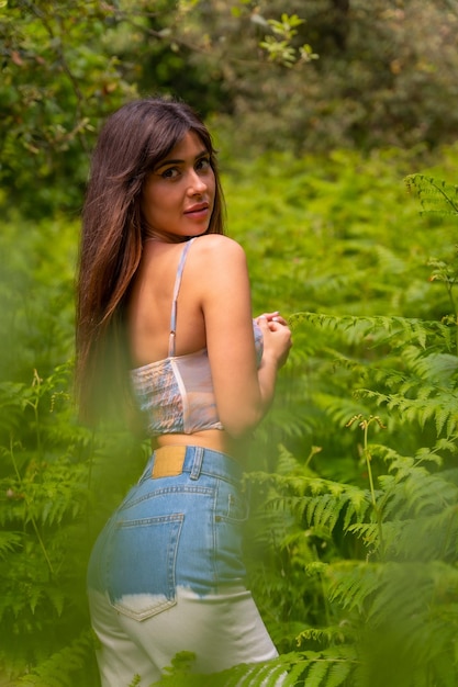 Portret van een blank meisje in varens op een berg omringd door de natuur verticale foto kijkend naar de camera