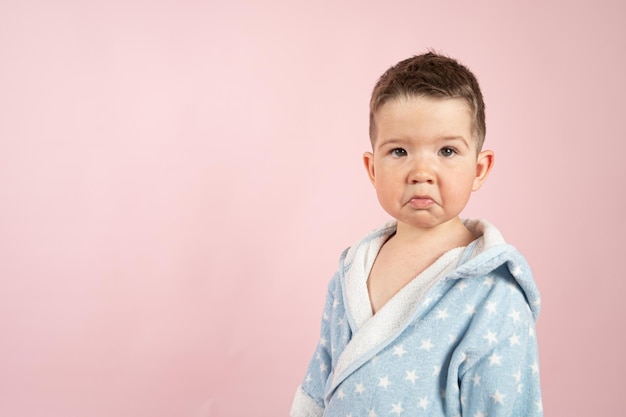 Portret van een blanke gefrustreerde brutale jongen op een roze achtergrond met kopieerruimte Foto van hoge kwaliteit