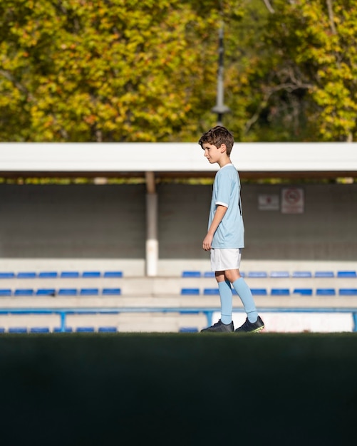 Portret van een blanke jongen die een voetbalstadion betreedt en ervan droomt professionele voetballer te worden Kopieer de ruimte