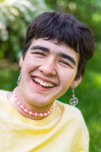 Portret van een blanke vrolijke jonge man met oorbellen in zijn oren