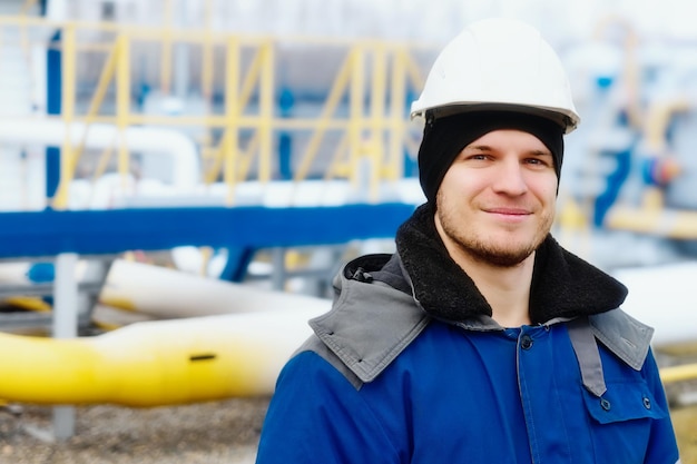 Portret van een blanke werknemer met een witte helm en een warm erwtenjack Exploitant van een tankstation