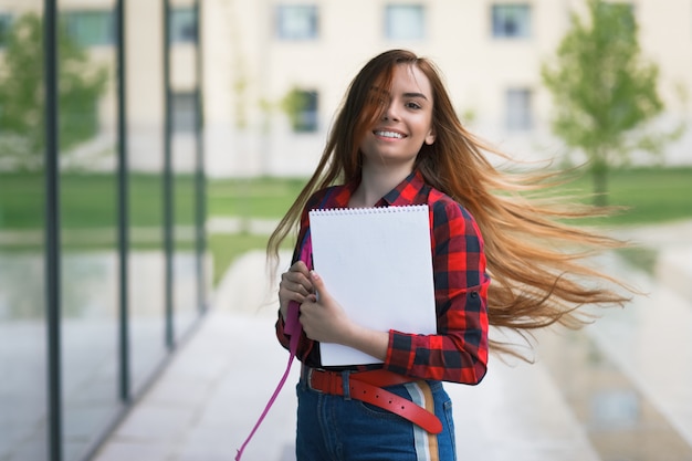 Portret van een blije studente met vliegend haar