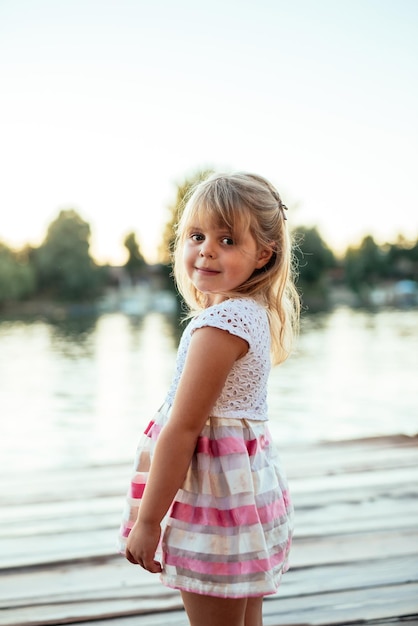 Portret van een blond meisje dat lacht bij de rivier