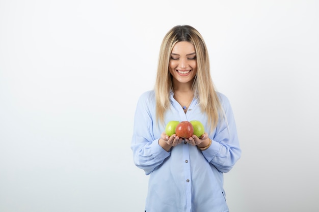 Portret van een blond meisje met groene en rode appels