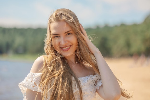 Portret van een blond meisje met lang haar op het strand op een zomerdag