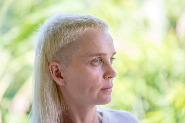 Foto portret van een blond meisje op een achtergrond van de natuur