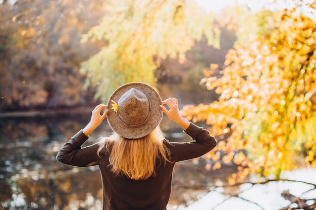 Foto portret van een blonde vrouw in zonnebril in herfst bos