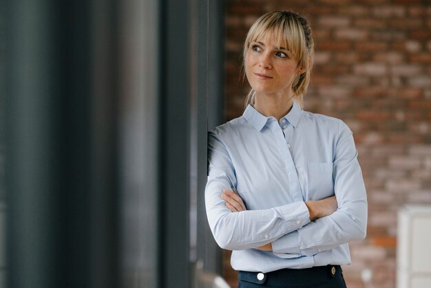 Portret van een blonde zakenvrouw met gekruiste armen