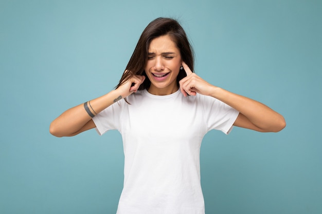 Portret van een boze ontevreden jonge mooie brunette vrouw met oprechte emoties die casual draagt