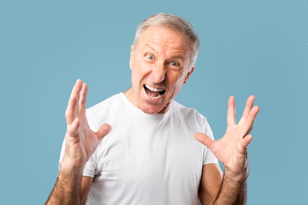 Portret van een boze volwassen man die schreeuwt in de studio