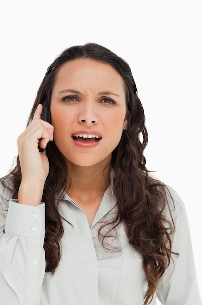 Portret van een brunette die terwijl het telefoneren grimassen