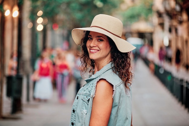 Portret van een brunette meisje met een hoed en tas