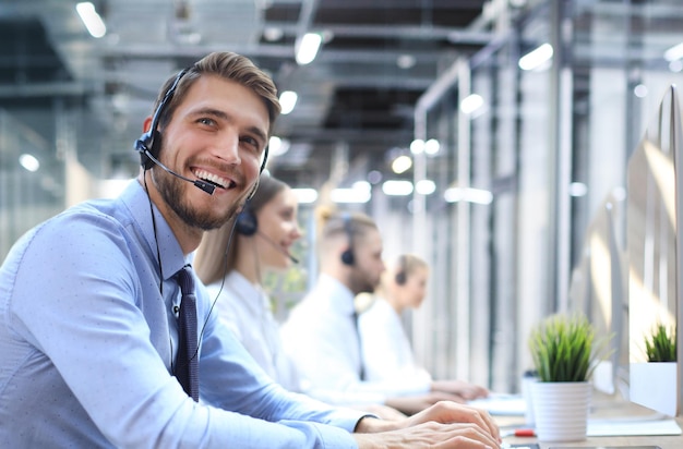 Portret van een callcenterwerker vergezeld van zijn team Glimlachende klantenserviceoperator aan het werk