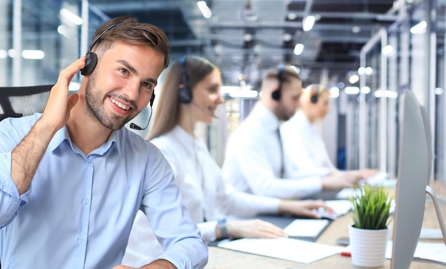 Portret van een callcenterwerker vergezeld van zijn team Glimlachende klantenserviceoperator aan het werk